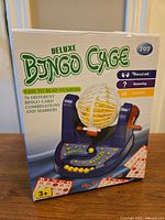 Photo showing the front of the Deluxe Bingo Cage box with bingo cage game set graphic.
