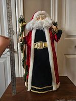 Front view of large vintage Santa figurine next to a ruler showing height