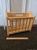 Front view of the wooden magazine rack with rulers to show size