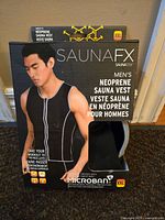 Front view of SaunaFX Men's Neoprene Sauna Vest in packaging, showing model wearing vest and product text detail.