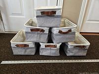 Six foldable canvas tote buckets stacked in a pyramid with ruler for size reference.