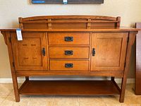 Front view of Bassett buffet showing decorative inlay on doors, three drawers, and bottom shelf