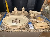 Overview of Pfaltzgraff Village servingware including platters, salt and pepper shakers, candleholders, measuring scoops and cups, butter dish, corn dishes with picks, and bread platters.