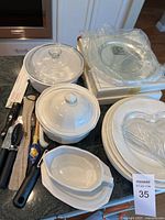 Wide shot of the lot showing covered casserole dishes, kitchen utensils, and some plates stacked