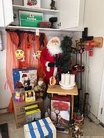 Full lot view showing Santa figure, Halloween decorations, Futaba RC controller box, clamps, candles, and grouped small items stacked in boxes.