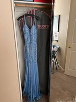 Blue formal Trudys Glow dress size 4 hanging in garment bag in closet