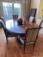 Wide angle shot showing the full dining table with 6 chairs around it and the additional leaf in place.