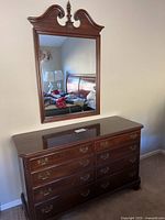 Dresser with mirror set against wall, eight drawers visible