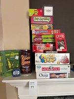 Photo of the full game bundle showing Monopoly, Ouija, Mouse Trap and other games stacked on a mantle.