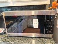 Full view of LG stainless steel microwave on kitchen counter showing the front door, control panel, and display.