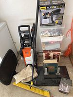 Overall view of lot showing pressure washer, broom, Wagner sprayer box, craft supply bins, decorative items