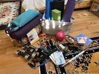Wide view of the full set with yoga bolsters, mats, weights, resistance bands, medicine ball, exercise DVDs, and basket.