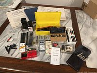 Overview of collection including papers, bottles of ink, trays and boxes of pen nibs, pen staffs, and other calligraphy supplies on table.