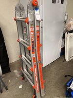 Shows folded side view of the Little Giant MegaLite ladder with visible branding on the side and orange plastic parts