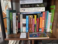 Shelf with a variety of nature-related books including titles on birds, insects, trees and wildlife.