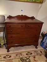 Full view of vintage dresser showing front, drawers closed, ball and claw feet.
