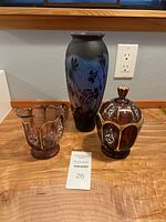 Photo of vintage Galle style cameo glass vase and Northwood Nestor amethyst glass sugar and creamer set on wooden table beneath window.