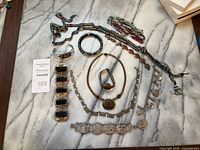Overview of the vintage jewelry collection including multiple bracelets and necklaces displayed on marble surface.