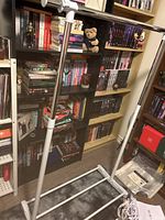 Clothing rack standing upright showing the base and hanging rail with white plastic components and chrome metal tubes.