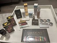 Top view of assorted cosmetics and skincare products on white table, including boxed and unboxed items