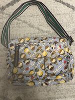 Front view of Harajuku Lovers PREPPIES crossbody bag showing adjustable striped strap, Velcro front pockets, and zippered pocket with blue tag.