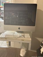 Front view of Apple iMac 2008 with wired keyboard and mouse on desk