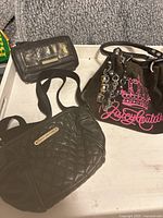 All three Juicy Couture bags in the lot arranged on a white surface, showing the velvet bag with pink logo and quilted small crossbody bags.