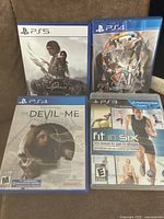 Shows front view of 4 PlayStation game cases stacked in two rows with cover art visible.