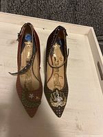 Top-down view of the right and left pumps showing the embroidered and embellished toes, ankle strap details and interior Sam Edelman logo.