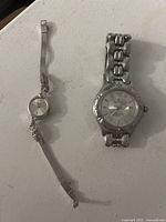 Photo showing both watches side by side on white surface: Waltham ladies watch (left) and Junghans wristwatch (right)