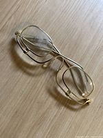 Close-up photo of the vintage gold-tone metal frame sunglasses showing the rectangular clear lenses and overall frame design.