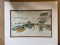 Photo of signed antique winter scene artwork showing snowy village with horse-drawn sleighs and buildings, signature visible bottom left