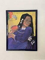 Framed painting depicting a woman holding an object, in style similar to Gauguin's Polynesian works.