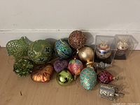 Photo of 14 assorted high end jeweled and sparkly Christmas ornaments in various shapes and colors, some stored in clear protective boxes