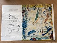 Photo showing handwritten note with Marc Chagall's signature and sketches next to artwork print.