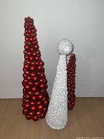 Large red ornament cone tree, medium white seashell cone tree, and smaller red ornament cone tree grouped together.