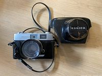 Konica Auto S2 camera with attached black leather carrying case, showing front and lens.