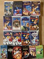 Top-down photo showing front cover artwork of all 16 VHS tapes, mostly Disney Black Diamond Collection titles with some other classics mixed in.