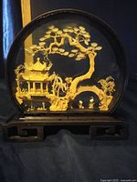 Front view of the intricate vintage Chinese carved cork scene inside a round glass case on a carved wooden base.
