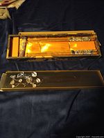 Decorative wooden box with gold fabric lining, open to show wrapped chopsticks inside.