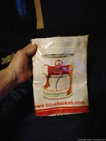 Photo of packaged Mae Ploy cooking apron held in hand, showing brand logo and packaging details.