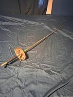 Full view of sword showing blade, handle, and cup-shaped guard