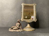 Full view of both bronze sculpture and desktop mirror, showing scale and positioning