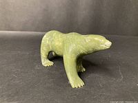 Front and side view showing the detailed bear carving in green stone with some surface wear.