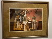 Framed print showing contemporary figure of woman with bottles, fruit, and flowers on table, capturing whole artwork and frame.