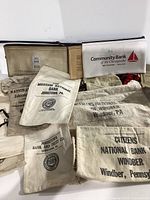 Photo showing a collection of cotton money bags and zippered bank pouches from various banks, mostly from Johnstown and Windber, Pennsylvania.