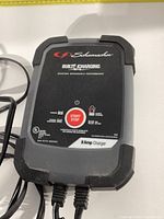 Top view of the Schumacher 8 Amp car battery charger showing the control panel, start/stop button, and indicator lights.