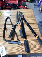 Garten tools lot shown on wooden surface: Fiskars loppers, shears, and folding hand saw
