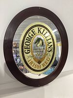 Full front view of oval mirror showing George Killians Irish Red logo and entire wooden frame.