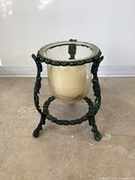 Full view of cast metal frame with glass votive and wax candle inside, showing overall condition.